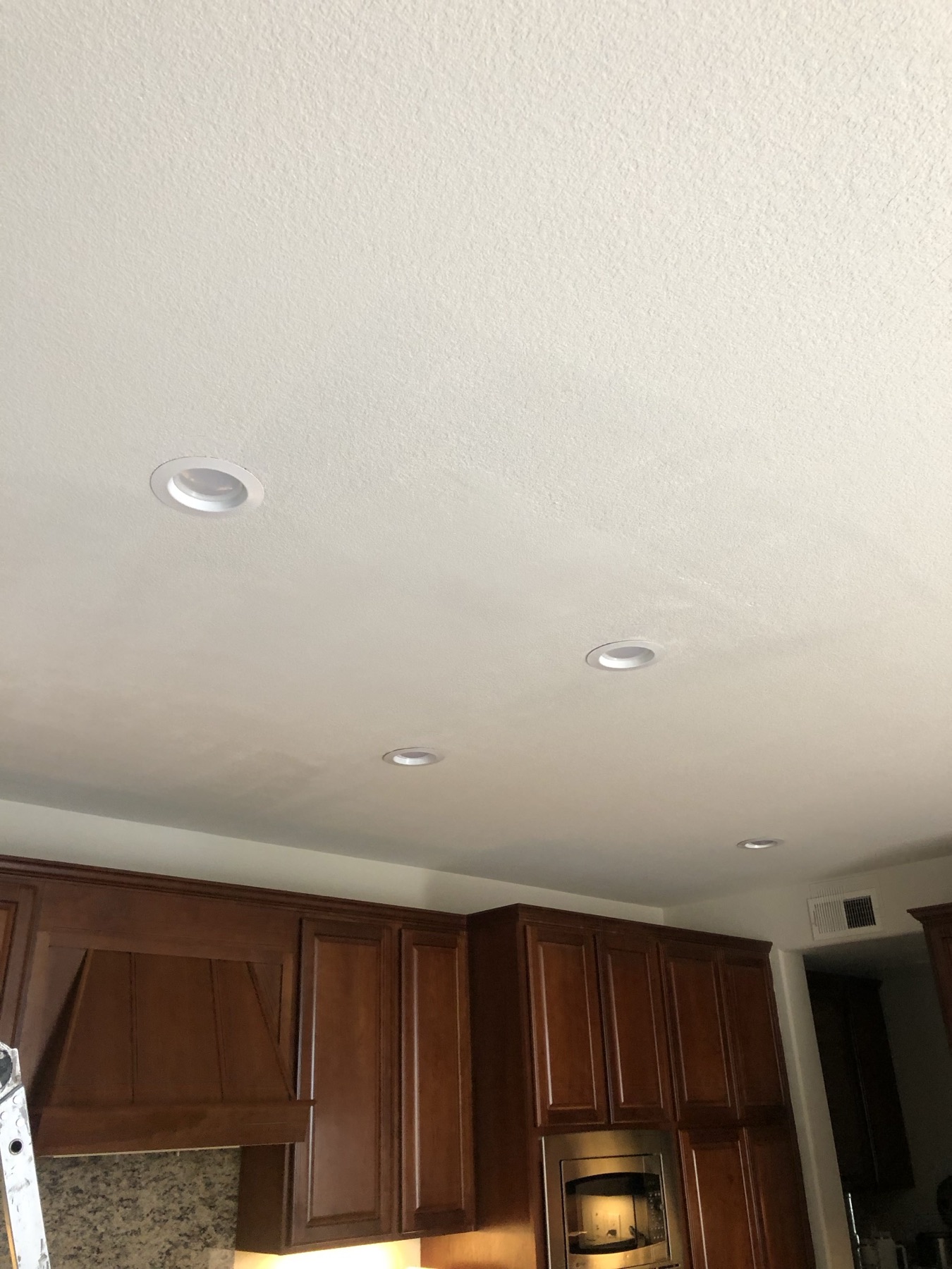 Evenly textured kitchen ceiling with recessed lights after a drywall repair
