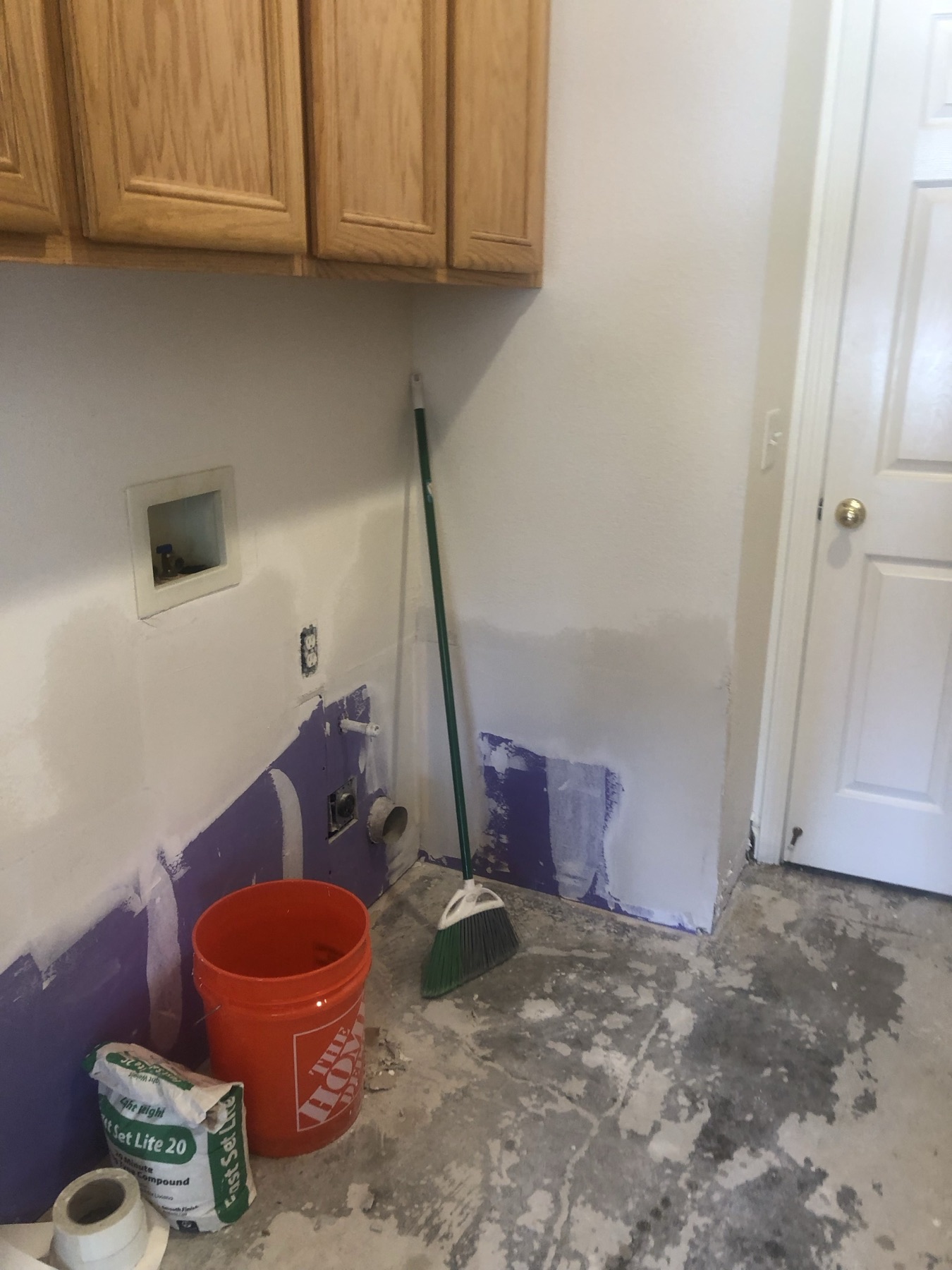 Laundry room wall with new drywall taped and mudded during a drywall repair